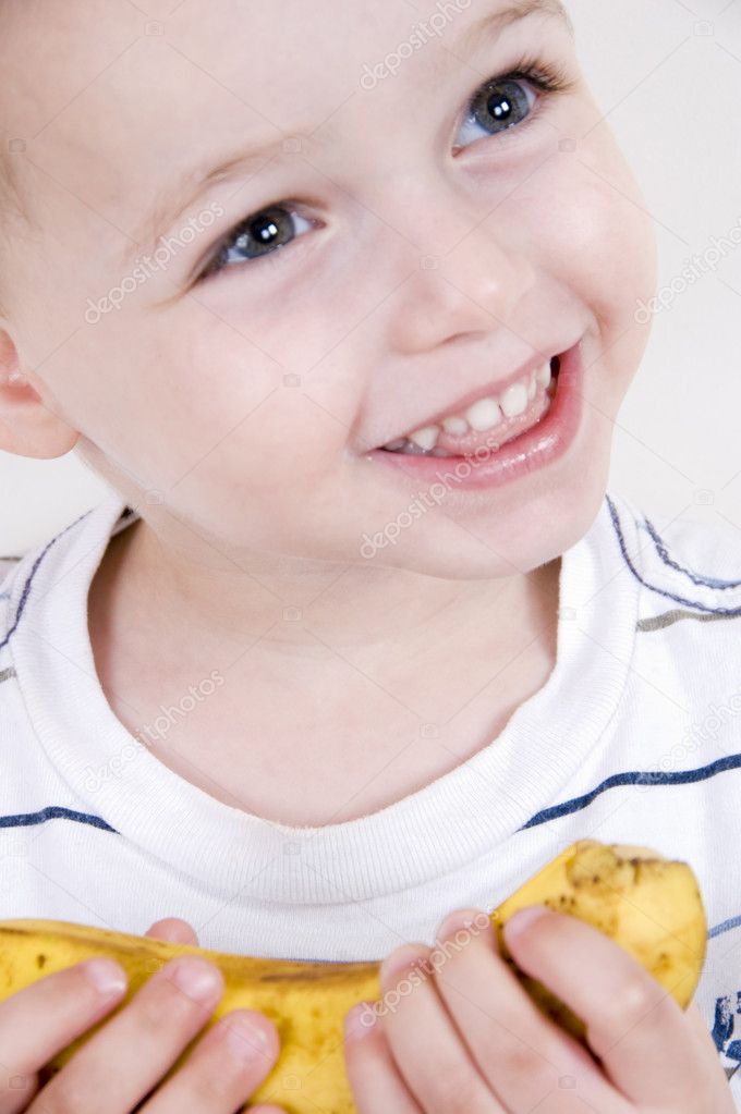 Close up of smiling boy with banana