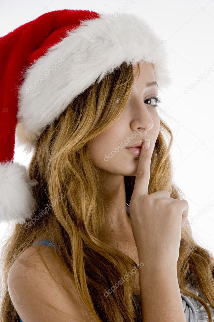 Teenage girl in christmas hat shushing