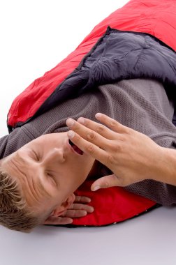 Man yawning in red sleeping bag clipart