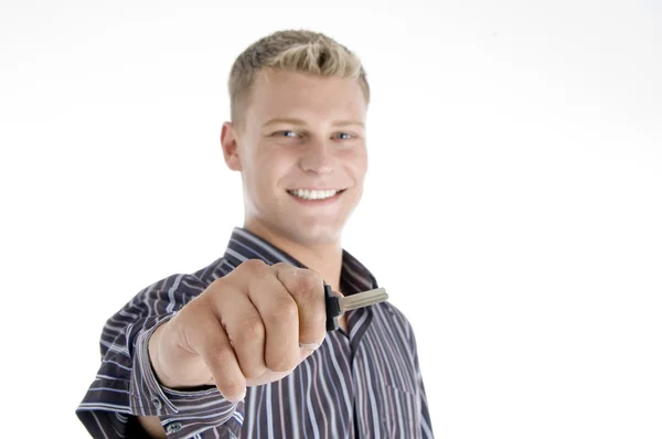 Sorrindo bonito homem segurando chave — Fotografia de Stock