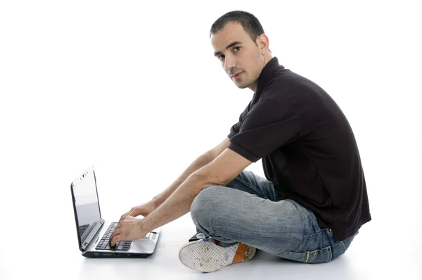 Dizüstü bilgisayarda çalışan yakışıklı genç adam — Stok fotoğraf