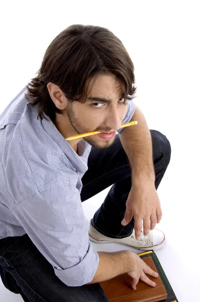Jeune étudiant tenant crayon dans la bouche — Photo