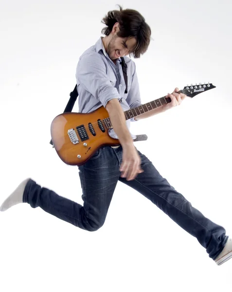 Young rock star jumping high in air — Stock Photo, Image