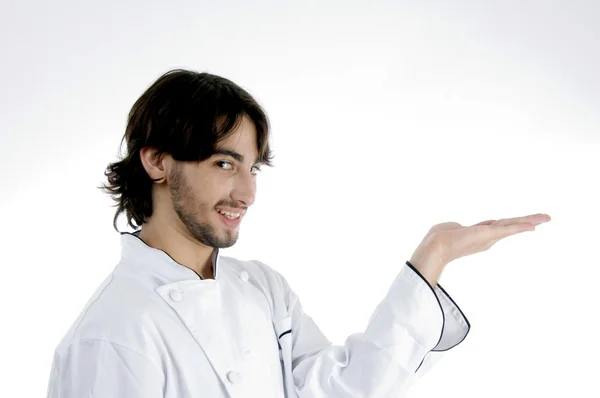 Handsome young chef with open palm — Stock Photo, Image