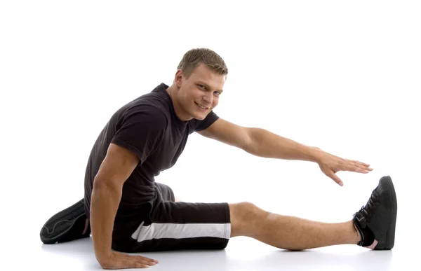 Giovane uomo in forma allungando le gambe — Foto Stock