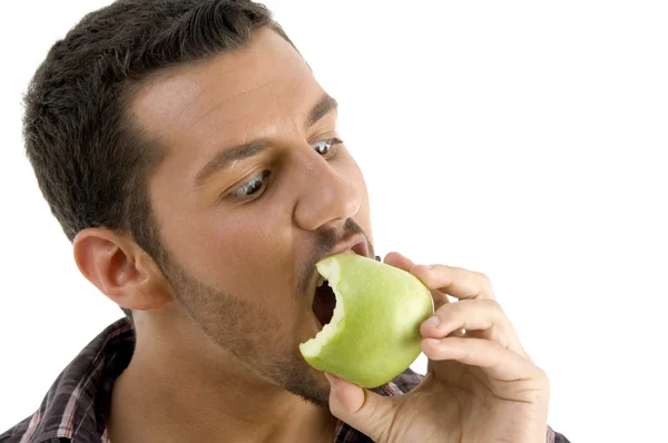 Молодий чоловік їсть зелене яблуко — стокове фото