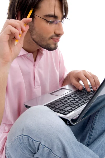 Jeune homme travaillant sur un ordinateur portable et pensant — Photo