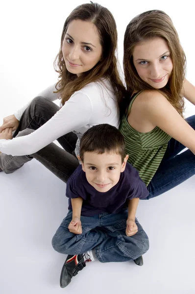 Молодой парень сидит со своими сестрами-подростками — стоковое фото