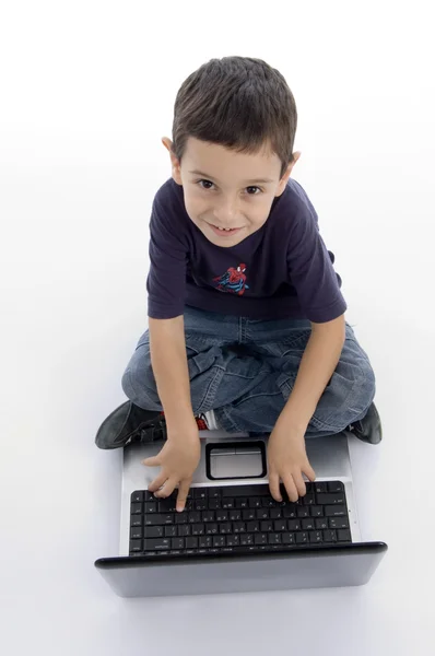 Маленький умный мальчик работает на ноутбуке — стоковое фото