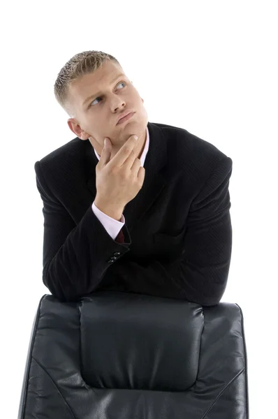 Denkender Geschäftsmann posiert hinter Stuhl — Stockfoto