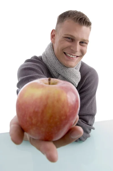 Усміхнений чоловік показує яблуко на камеру — стокове фото