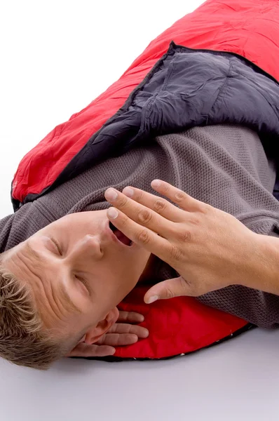 Homem bocejando em saco de dormir vermelho — Fotografia de Stock