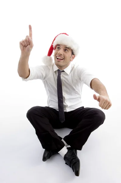 Young man with christmas hat pointing up — Stock Photo, Image