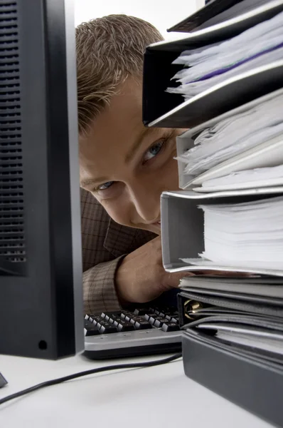 Young man looking between files and pc — Stock Photo, Image