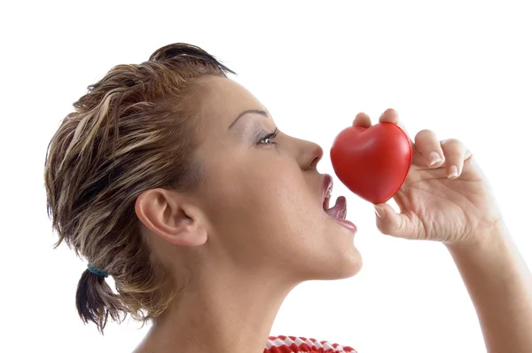 Face lateral da mulher lambendo um coração — Fotografia de Stock