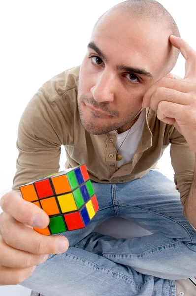 Збентежений чоловік тримає кубик-головоломка — стокове фото