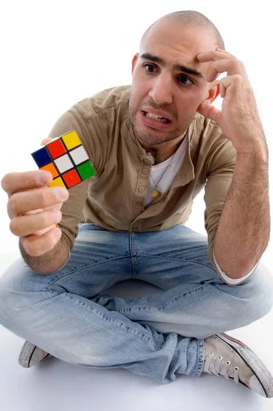 Confuso masculino segurando cubo de quebra-cabeça — Fotografia de Stock