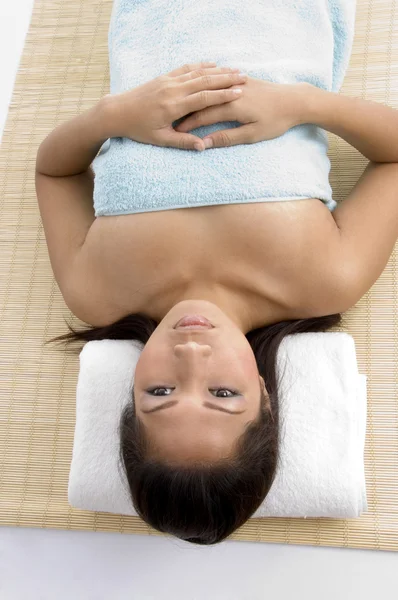 Young woman resting on mat before spa — Stock Photo, Image