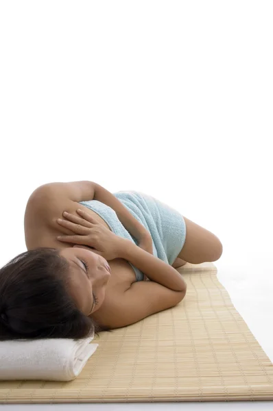 Νεαρή γυναίκα στην ξαπλωτή στάση χαλάρωσης σε χαλί — Φωτογραφία Αρχείου
