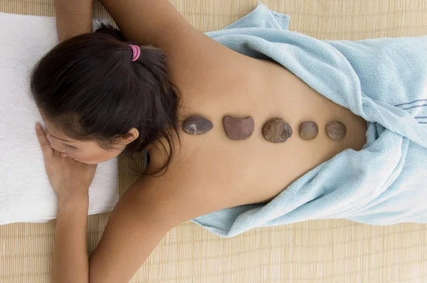 Mujer joven relajándose en la terapia de piedra —  Fotos de Stock
