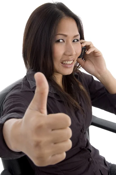 Woman showing thumbs up while talking — Stockfoto