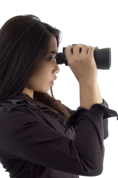 Vrouw die door een verrekijker kijkt — Stockfoto