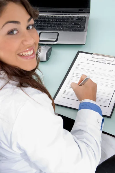 Médico sonriente escribiendo prescripción —  Fotos de Stock