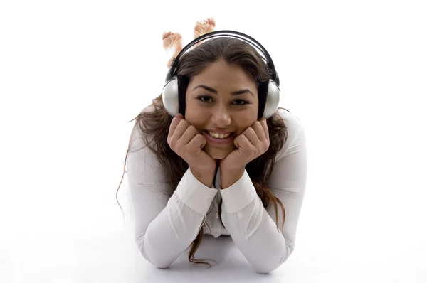 Unga kvinnliga ligger och njuter musik — Stockfoto