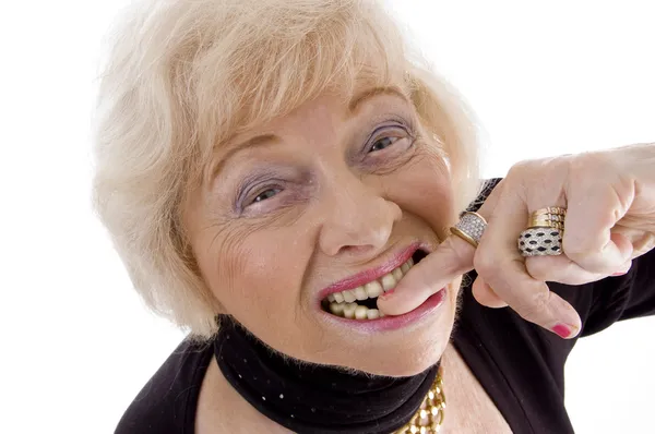 Old woman keeping finger in her mouth — Stock Photo, Image