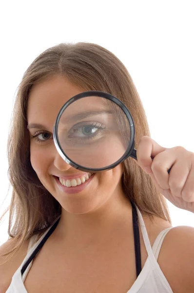 Smiling model holding magnifying glass — Stock Photo, Image