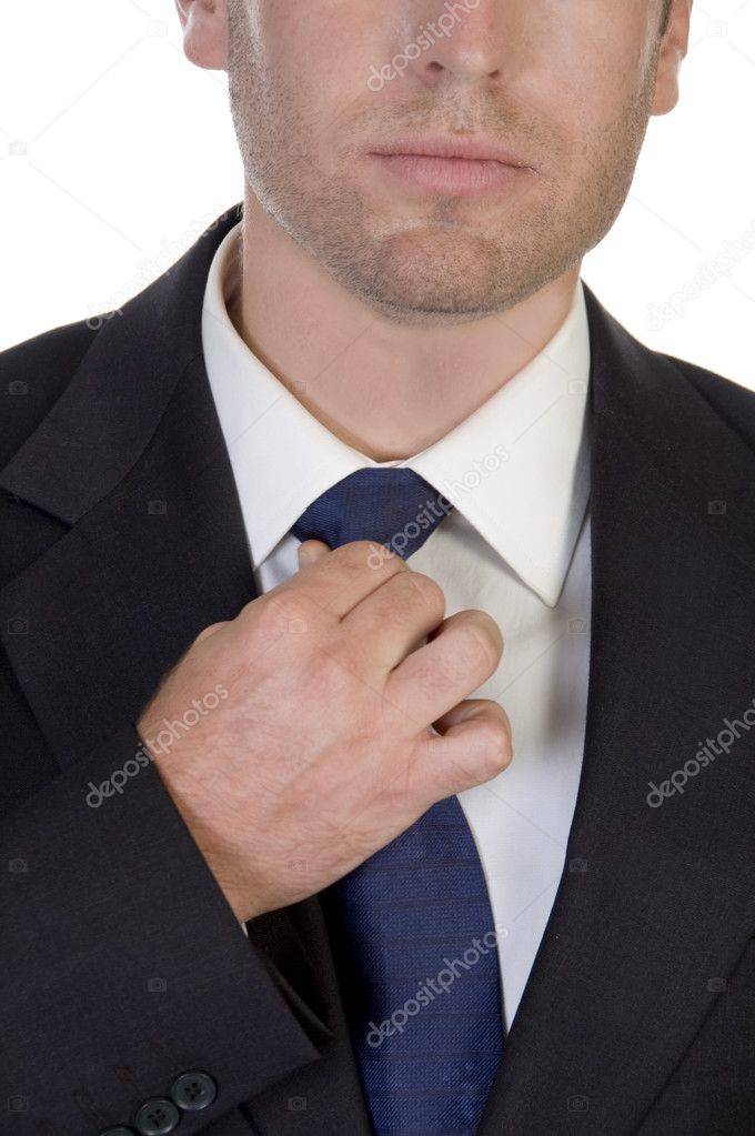 Young businessman fastening his tie