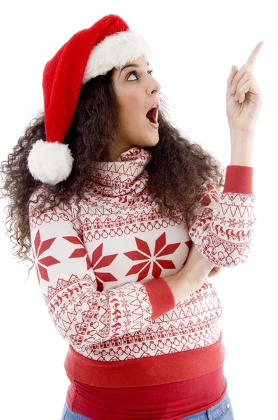 Young woman in christmas hat indicating — Stock Photo, Image