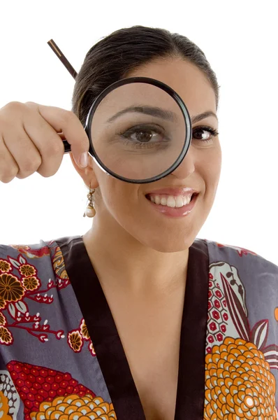 Emale watching through magnifying lens — Stock Photo, Image