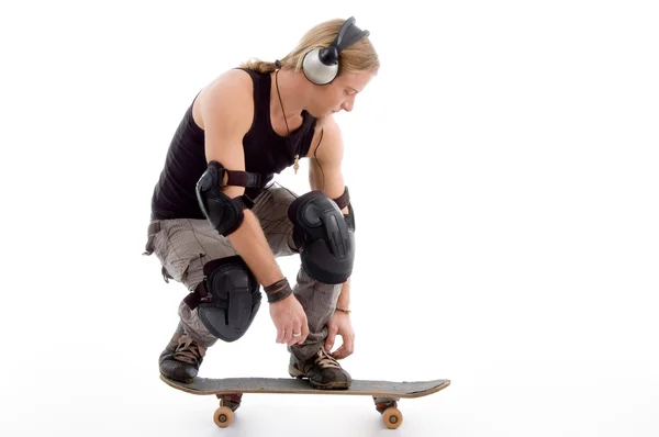 Jonge kerel genieten van muziek op skateboard — Stockfoto