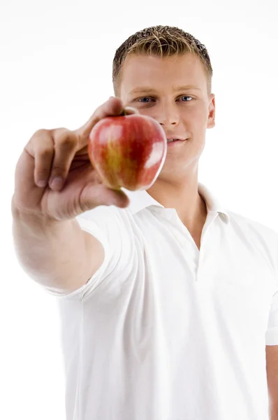 Modelo masculino fresco que muestra una manzana — Foto de Stock