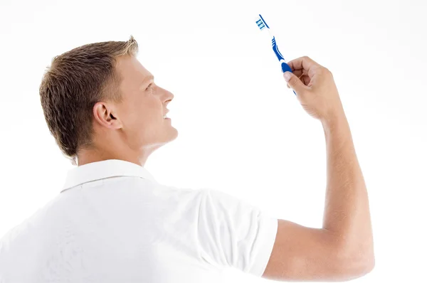 Handsome male looking at toothbrush — Stock Photo, Image