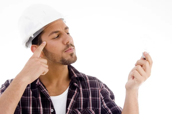 Innovative male looking at electric bulb — Stock Photo, Image