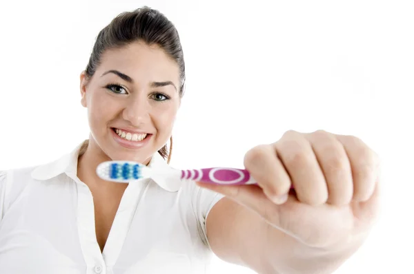 Lächelnde Frau zeigt Zahnbürste — Stockfoto
