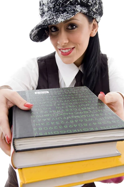 Студент у кепці тримає стек книг — стокове фото