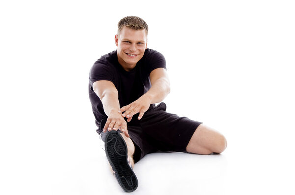 Muscular man stretching his legs