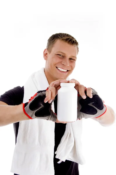 Muskulöser Kerl zeigt Medikamentenflasche — Stockfoto