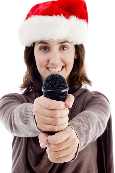 Молодая женщина в шляпе Санты держит микрофон — стоковое фото