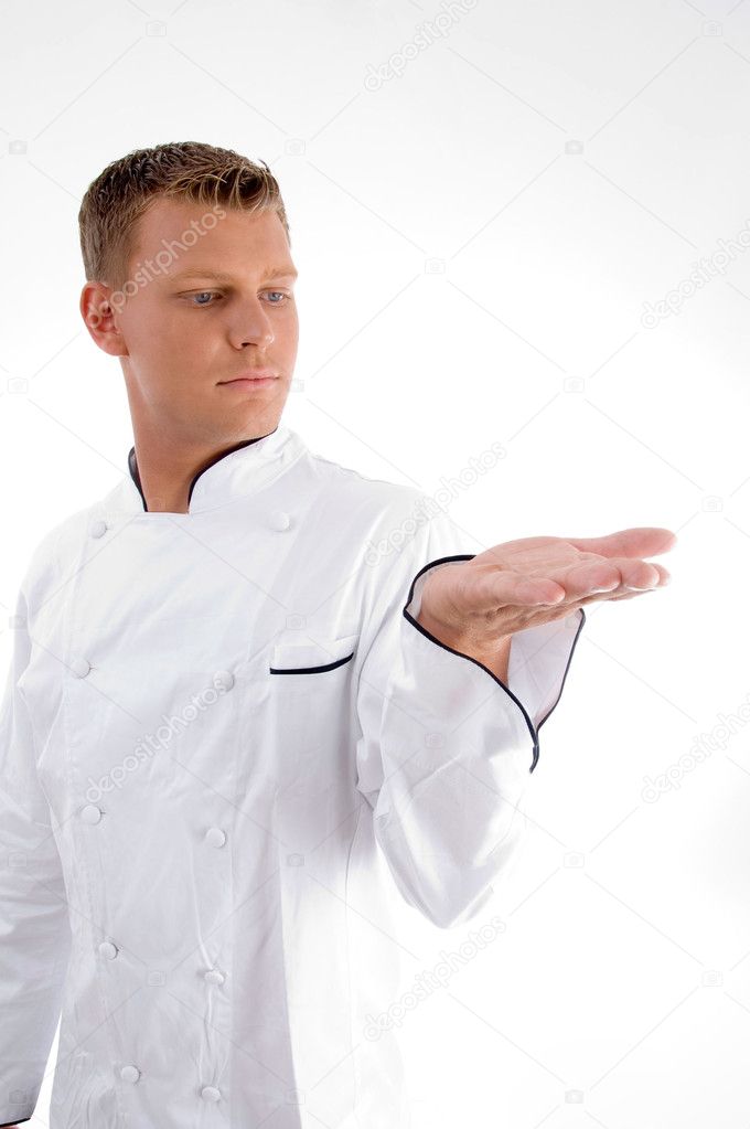 Handsome young chef looking at his palm