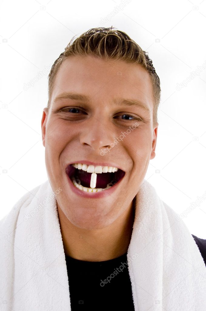 Man holding capsule between his teeth