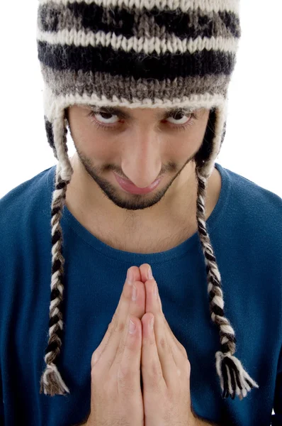 Умный молодой парень в зимней кепке молится — стоковое фото