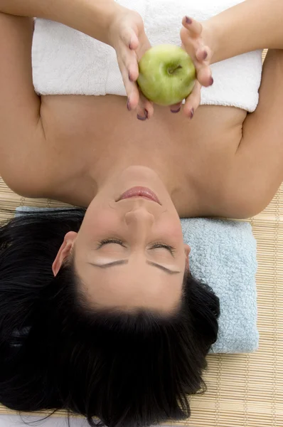 Mujer joven en spa sosteniendo una manzana — Foto de Stock