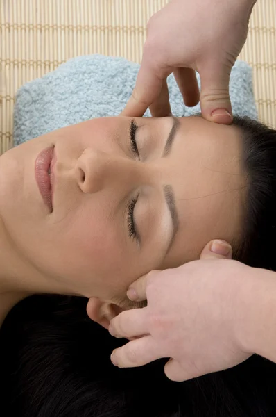 Jovem mulher tomando massagem na cabeça — Fotografia de Stock