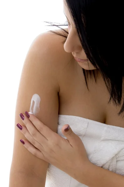 Portrait of young woman applying lotion — Stock Photo, Image