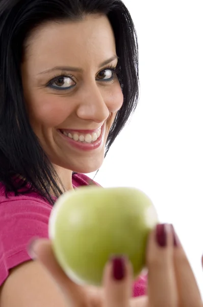 Задоволена молода жінка пропонує яблуко — стокове фото