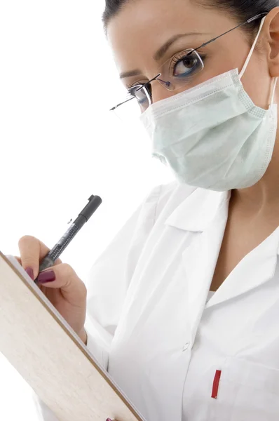 Kobieta lekarz z maska, pisanie — Zdjęcie stockowe